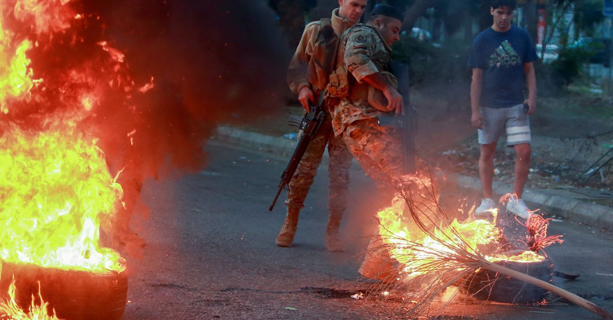 lebanese army soldiers attempt to open a road that was blocked by demonstrators during a protest on the back of the continuing deterioration of living conditions in sidon lebanon november 29 2021 reuters