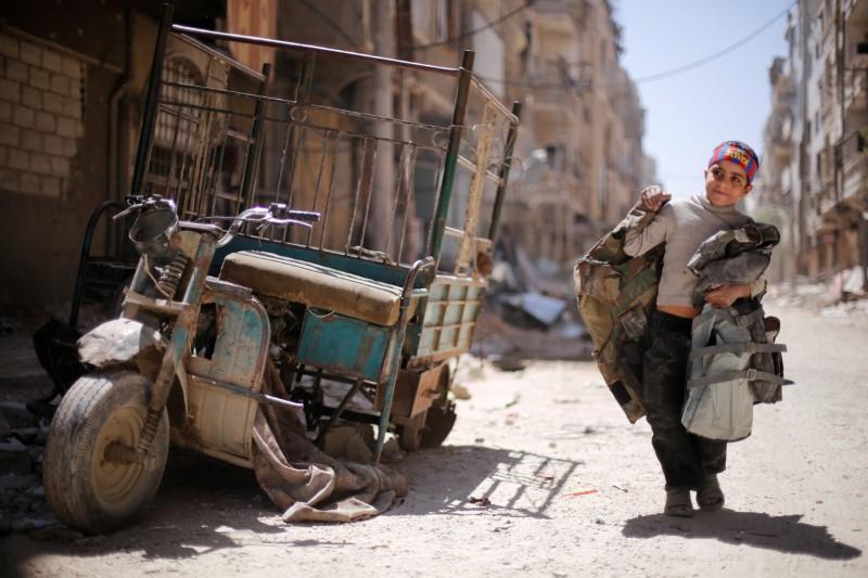 a boy walks along a damaged street at the city of douma in damascus syria reuters