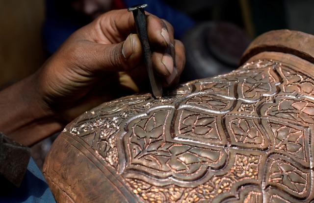 file photo a kashmiri artisan engraves designs on a traditional copper samovar inside his workshop in downtown srinagar march 1 2021 picture taken march 1 2021 reuters sanna irshad mattoo file photo reuters