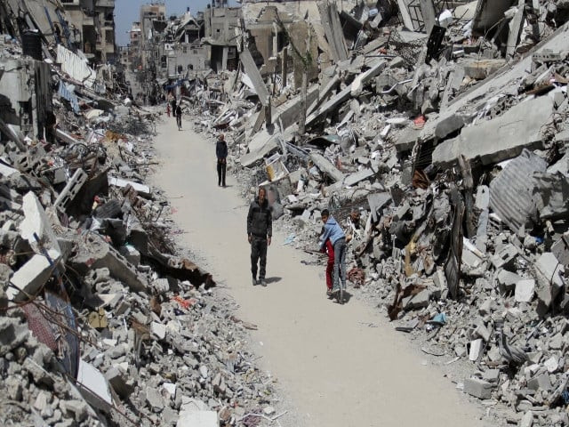 palestinians walk past the ruins of houses in the northern gaza strip march 31 2024 reuters