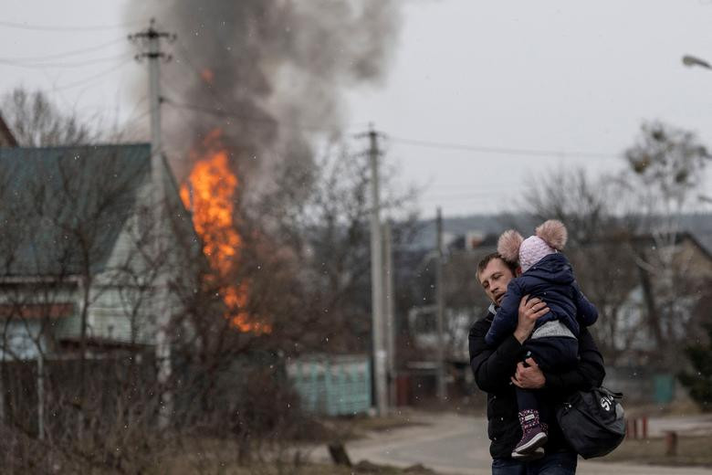 Local residents escape from the town of Irpin, after heavy shelling landed on the only escape route used by locals, as Russian troops advance towards the capital of Kyiv, in Irpin, near Kyiv, Ukraine March 6, 2022. REUTERS