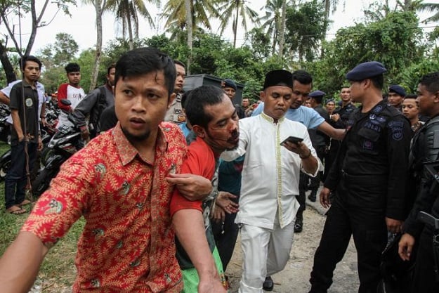 A plainclothes policeman (L) detains a prisoner who escaped from the Sialang Bungkuk jail in Pekanbaru on Indonesia's Sumatra island, May 5, 2017 PHOTO: REUTERS