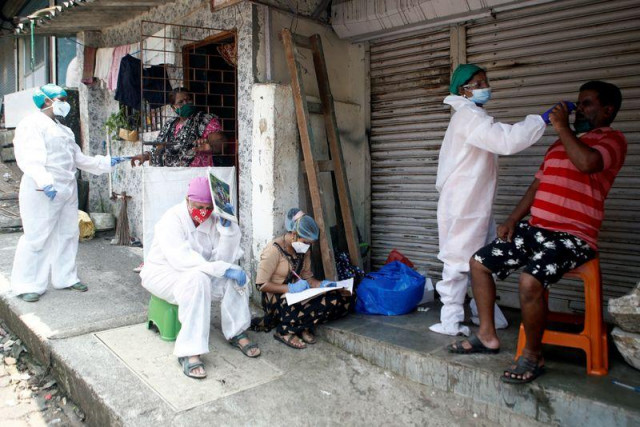 file photo a health worker in personal protective equipment ppe rests as her colleagues test residents of a slum area during a check up campaign for the coronavirus disease covid 19 in mumbai india september 5 2020 reuters