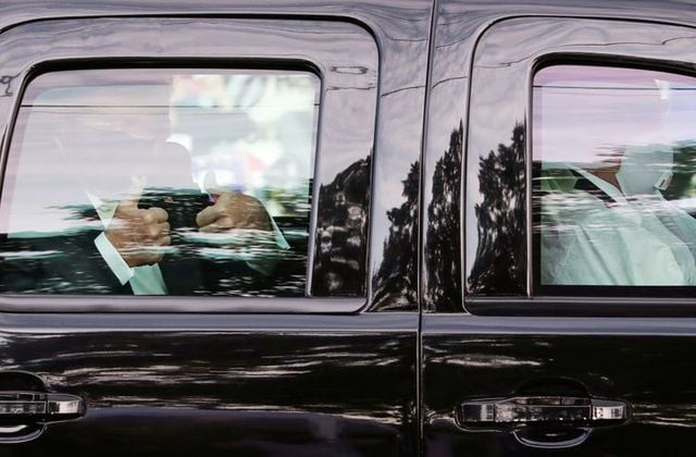 us president donald trump gives two thumbs up to supporters as he rides in the presidential suv with two u s secret service agents wearing medical protective masks goggles and protective gowns in the front seat as they drive past the front of walter reed national military medical center where he is being treated for covid 19 in bethesda maryland us october 4 2020 reuters