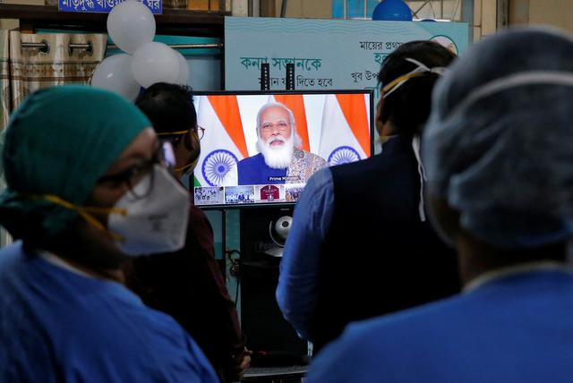 healthcare workers watch indian prime minister narendra modi addressing them through video conferencing to launch one of the world s largest covid 19 vaccination campaigns at a government run hospital in kolkata india january 16 2021 reuters