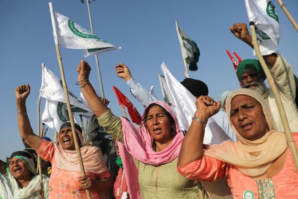 women shout slogans at an expressway which was blocked by farmers to mark the 100th day of the protest against the farm laws near kundli border in haryana india march 6 2021 reuters