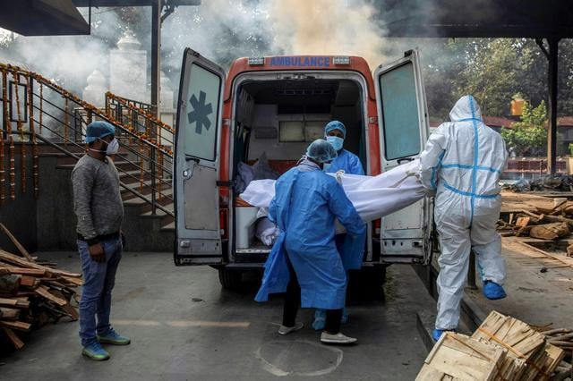 health workers and a relative carry the body of a man who died due to covid 19 from an ambulance to a crematorium in new delhi india november 13 2020 reuters health workers and a relative carry the body of a man who died due to covid 19 from an ambulance to a crematorium in new delhi india november 13 2020 reuters