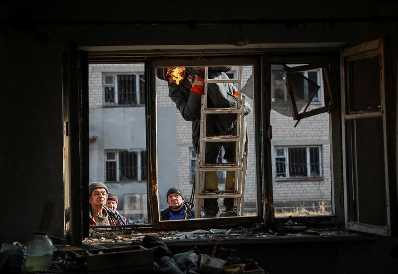 Communal workers look into a destroyed house after yesterday's shelling near the front line near the city of Novoluhanske in the Donetsk region, Ukraine, February 22. REUTERS