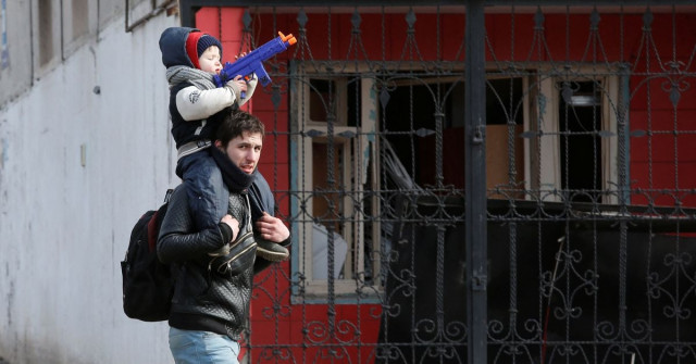 a child sits on the shoulders of a man near a building damaged during ukraine russia conflict in the besieged southern port city of mariupol ukraine march 20 2022 reuters a child sits on the shoulders of a man near a building damaged during ukraine russia conflict in the besieged southern port city of mariupol ukraine march 20 2022 reuters