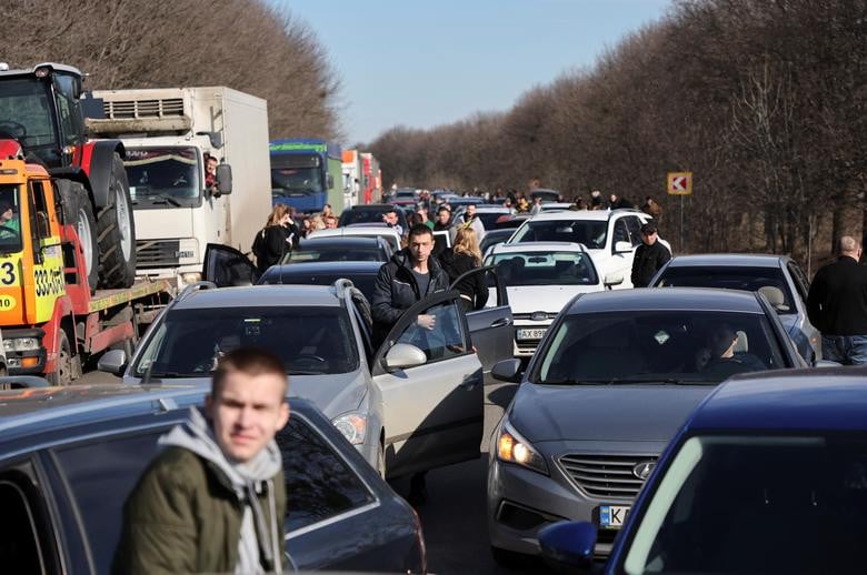 People wait in a traffic jam as they leave the city of Kharkiv, February 24. REUTERS