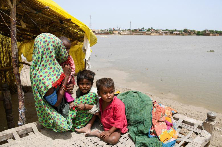 a woman and chidren sit outside their tent after taking refuge on a higher ground following rains and floods during the monsoon season in jamshoro pakistan august 26 2022 photo reuters