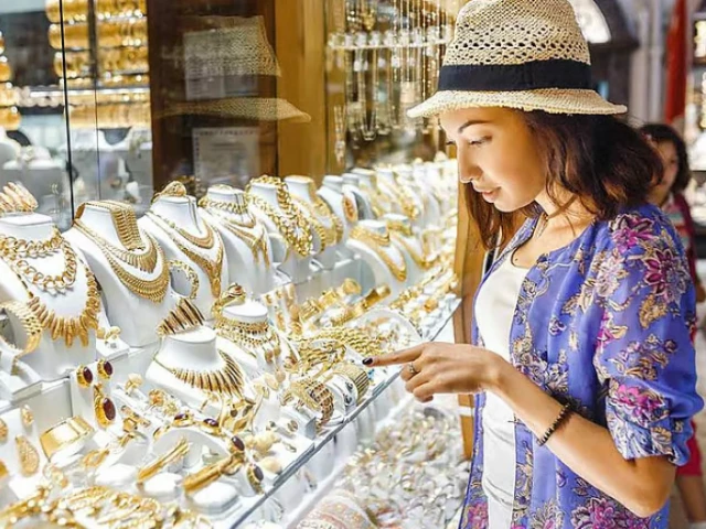 a tourist is looking at the gold items in dubai shop display photo gulf news a tourist is looking at the gold items in dubai shop display photo gulf news
