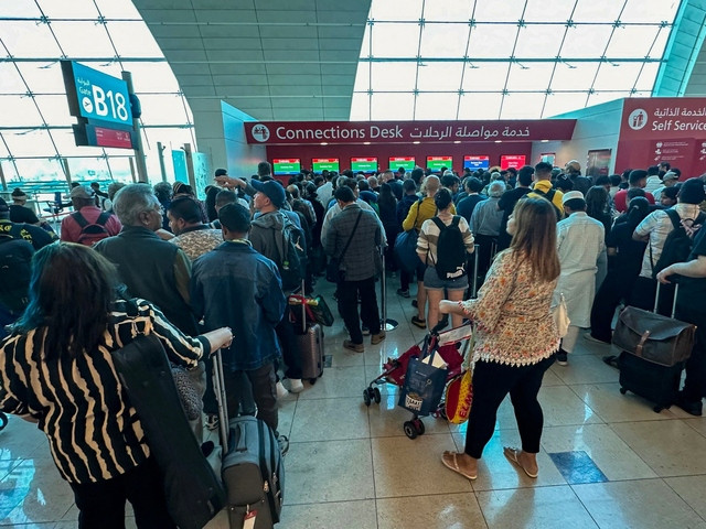 passengers queue at a flight connection desk at the dubai international airport dubai s major international airport diverted scores of incoming flights on april 16 as heavy rains lashed the united arab emirates causing widespread flooding around the desert country photo afp