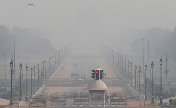 People walk near India Gate on a smoggy afternoon in New Delhi, India, November 15, 2020. REUTERS