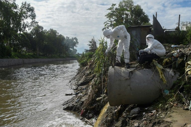 researchers in nepal collect samples of sewage dumped into a river to trace the coronavirus spread afp