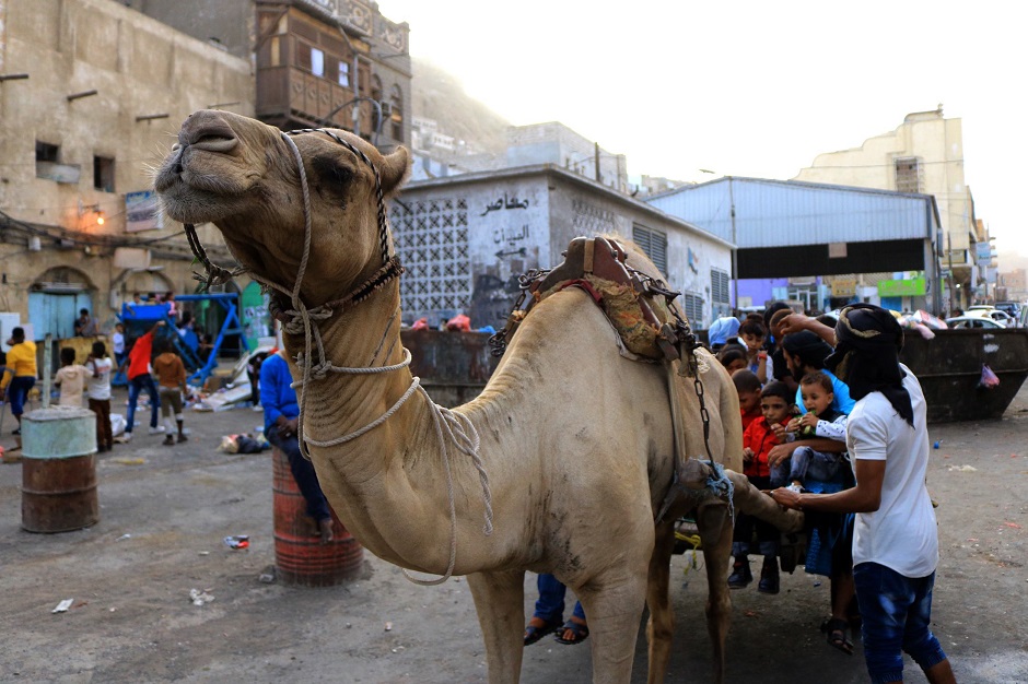 Yemeni children sit behind a camel as people celebrate Eidul Azha in Aden. PHOTO: AFP