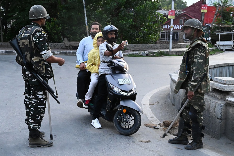 A motorist shows his identity card to a security personnel after being stopped for questioning at a roadblock during a lockdown in Srinagar. PHOTO: AFP