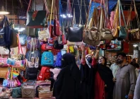 people look at handbags on display outside shops in a market ahead of eidul fitr celebrations in karachi photo reuters