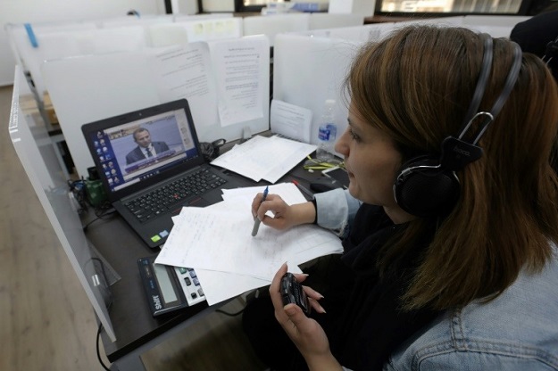 An employee of the electoral monitoring committee watches a televised speech of a Lebanese parliamentary candidate and records the time of his speech at the headquarters of the committee in Beirut on April 11, 2018. PHOTO: AFP