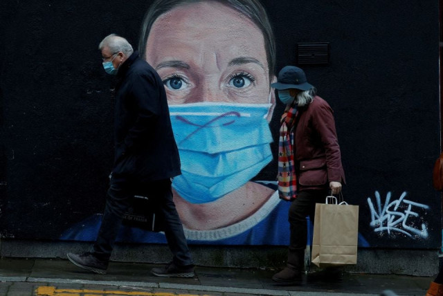 people wearing face masks walk past a mural of a nurse in the centre of manchester britain november 29 2021 photo reuters file people wearing face masks walk past a mural of a nurse in the centre of manchester britain november 29 2021 photo reuters file