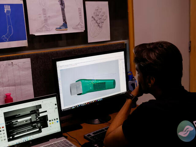 A technician works on computers with prosthetic limb diagram at Bioniks in Karachi, April 29, 2024. — Reuters