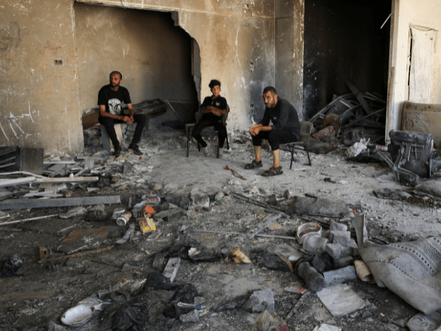 Palestinians sit as they inspect damage in the aftermath of an overnight Israeli strike on Al-Remal clinic where displaced people take shelter in Gaza City on July 7, 2025. — Reuters