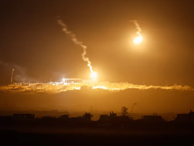 Flares fired by Israeli forces light up the night sky above Gaza [Amir Cohen/Reuters]