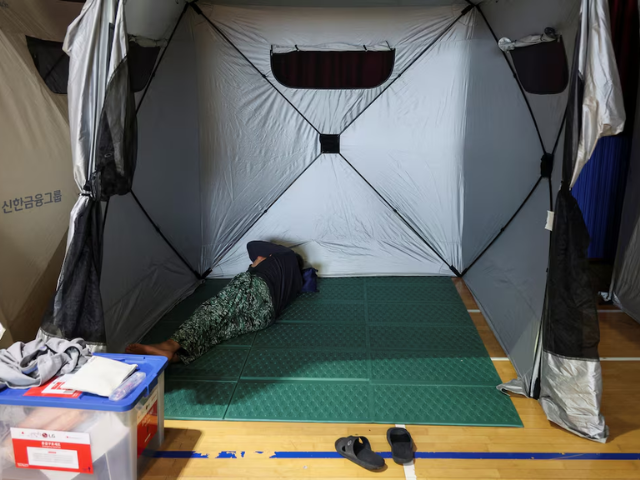 A person evacuated from a village, damaged by torrential rain, rests at a temporary shelter, in Yesan, South Korea, July 18, 2025. REUTERS/Kim Hong-Ji