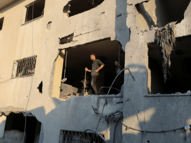 Palestinians look on while standing at the site of an overnight Israeli air strike on a house in Gaza City on July 23, 2025. — Reuters
