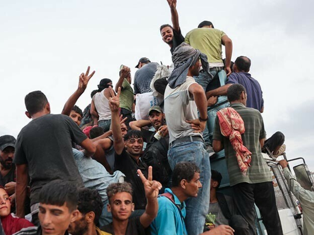 Palestinians climb in the back of a truck on a coastal path west of Beit Lahia after managing to get aid parcels on July 29, 2025, after aid trucks entered the Israel-besieged Gaza Strip from the northern Zikim border crossing. — AFP