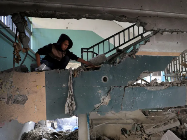 A boy inspects the damage at the site of an Israeli air strike on a school building, now sheltering displaced people, in Gaza City Photo: reuters