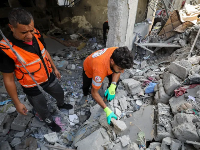 Members of the Palestinian Civil Defence work at the site of an Israeli strike in Gaza City [Reuters]