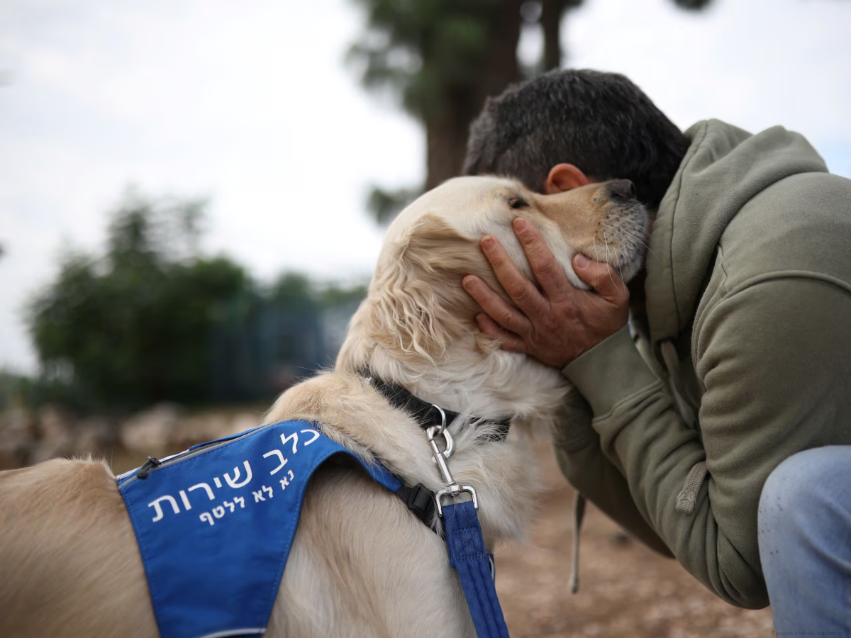 A former soldier being treated for PTSD at the Combat Veterans Psychedelic Research Clinic at Emek Medical Center, embraces his service dog, in Afula, Israel December 15, 2025. REUTERS