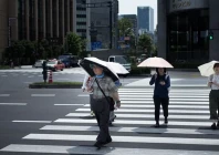 people hold umbrellas as they walk along a street in tokyo afp
