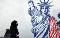 an iranian woman walks past an anti us mural next to the former us embassy in tehran on february 26 afp