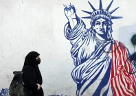 an iranian woman walks past an anti us mural next to the former us embassy in tehran on february 26 afp