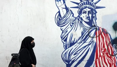 an iranian woman walks past an anti us mural next to the former us embassy in tehran on february 26 afp
