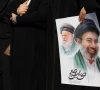a woman holds an image of iran s new supreme leader mojtaba khamenei alongside late iranian supreme leader ayatollah ali khamenei during a funeral ceremony for the iranian military commanders who were killed in strikes amid the u s  israeli conflict with iran in tehran iran march 11 2026 majid asgaripour wana west asia news agency via reuters