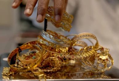 a goldsmith weighs gold jewellery inside a showroom in ahmedabad reuters