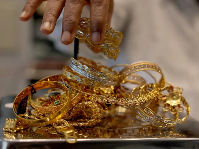 a goldsmith weighs gold jewellery inside a showroom in ahmedabad reuters