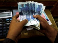 a trader counts pakistani rupee notes at a currency exchange booth in peshawar pakistan december 3 2018 reuters