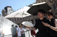 two people shelter under an umbrella and use a fan outside the louvre amid a severe heat wave in paris france photo reuters