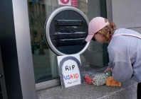 a person leaves flowers next to a usaid sign which is covered over at the agency s headquarters in washington us photo reuters