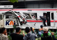 people watch as a technician works at the site after a deadly collision between a commuter line train and a long distance train in bekasi on the outskirts of jakarta photo reuters