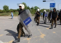 police officers equipped with riot gear walk at d chowk area near the president s house as pakistan prepares to host the us and iran for peace talks in islamabad photo reuters