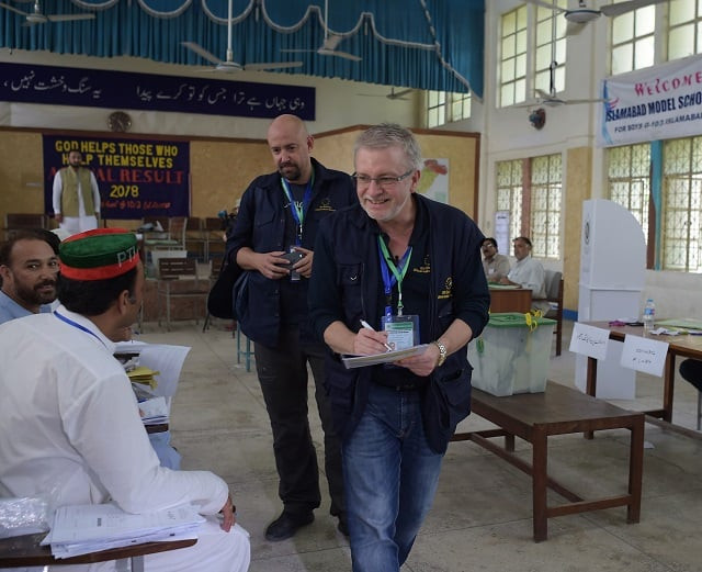 european union election observer officials speak to political parties agents at a polling station during pakistan s general election in islamabad on july 25 2018 photo afp file