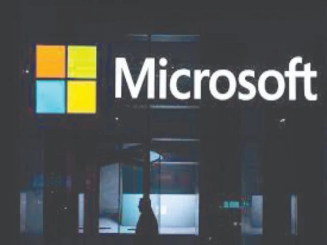 a visitor walks past a logo of microsoft photo afp