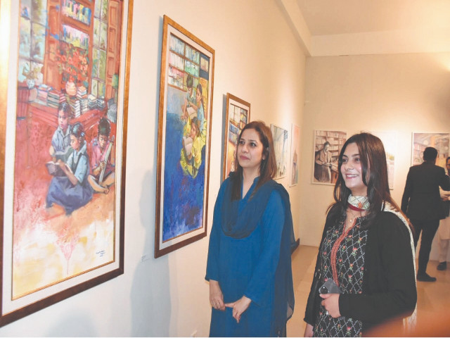 visitors explore the captivating artworks displayed at the rebinding the library exhibition at the national council of the arts in islamabad the paintings vividly portray the shared yet solitary experience of individuals engaging with books in libraries photo online