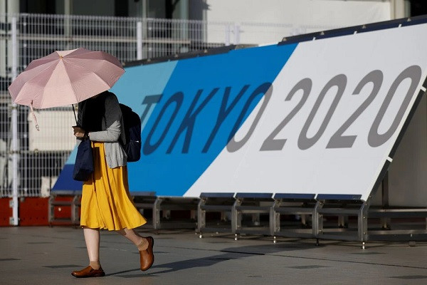 a woman walks past tokyo 2020 olympic games signage at the main press center during the coronavirus disease covid 19 outbreak in tokyo japan july 16 2021 reuters