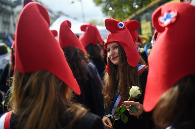 Protesters wearing Phrygian hats take part in a protest against a government plan to let single women and lesbians become pregnant with fertility treatments. PHOTO: AFP